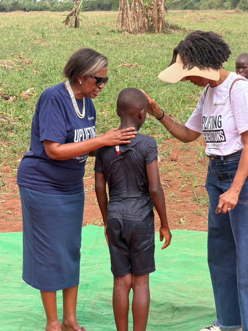 Pastor Agatha and Pastor Cheryl praying over a newly baptised child